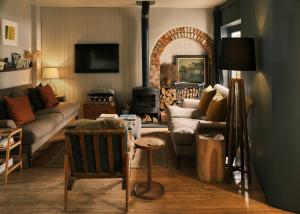 a living room with a couch and a fire place at Historic Brewery Cottage in Dorset Village Sleeps 10 in Fontmell Magna