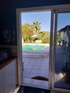 an open sliding glass door with a view of a swimming pool at Casa Papaver Relax Appartement in Coín +2 photos
