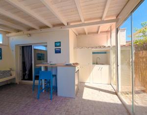 a kitchen with a counter and a table and chairs at LA PERLA BIANCA Apartment - Near Train Station and Best Beaches with Amazing Sunsets in Anzio