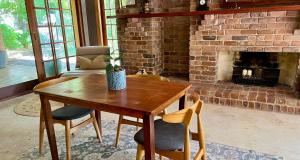 a living room with a table and a fireplace at Bodhi Valley BnB in Golden Grove