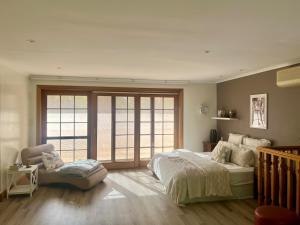 a bedroom with a large bed and a large window at Bodhi Valley BnB in Golden Grove