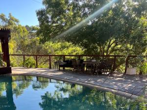 a patio with a table and chairs next to a pool at Bodhi Valley BnB in Golden Grove