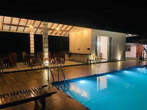a swimming pool with a table and chairs in a building at Rainforest Mount Villa in Nelluwa