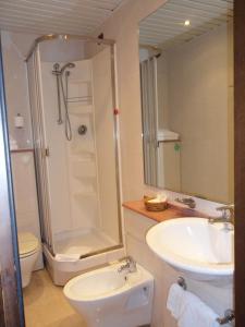 een badkamer met een douche, een wastafel en een toilet bij Masseria Gattamora in Uggiano la Chiesa