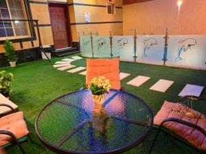 a glass table with a vase of flowers on it at شالية سحاب in Rayyis