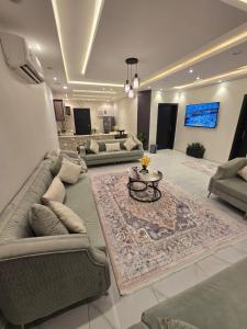 a large living room with couches and a table at شالية سحاب in Rayyis