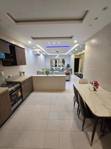 a large kitchen and dining room with a table at شالية سحاب in Rayyis