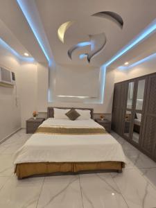 a bedroom with a large bed with blue lights on the ceiling at شالية سحاب in Rayyis +10 photos