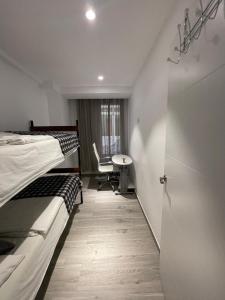 a room with two beds and a desk and a table at Igidelux 2 in Villajoyosa
