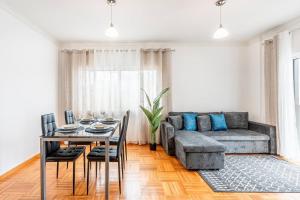 a living room with a couch and a table at Sapphire Scape Near Airport Madeira Santa Cruz in Gaula