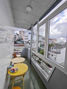 a room with two tables and two windows at Guesthouse Big Lucky in Da Lat