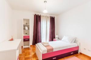 a white bedroom with a bed and a window at Sapphire Scape Near Airport Madeira Santa Cruz in Gaula