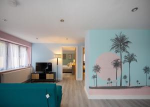 a living room with a bedroom with palm trees on the wall at Private 2 Bed Escape with Huge Parking in Ely