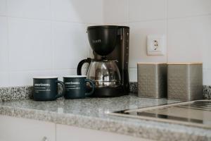 a group of coffee mugs sitting on a counter at Sapphire Scape Near Airport Madeira Santa Cruz in Gaula