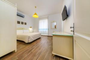 a hotel room with a bed and a television at NG Guest House Ammentos in Olbia +112 photos