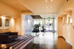 an office lobby with a couch and a glass door at Exclusive Stays - Southpoint in Melbourne
