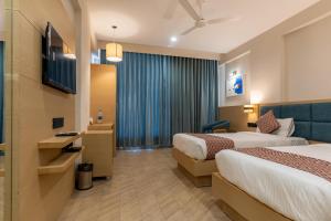 a hotel room with two beds and a television at Hotel Altura CHHATRAL in Nandāsan +36 photos
