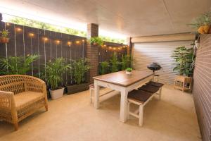 a patio with a wooden table and chairs and plants at Humble & Homely in Rockingham