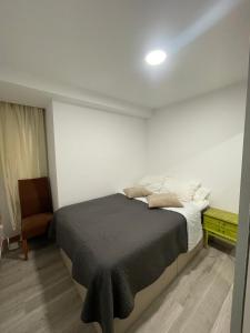 a bedroom with a bed and a chair at Igidelux 2 in Villajoyosa +2 photos