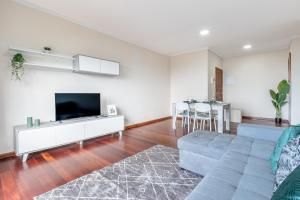 a living room with a couch and a tv at Emerald Scape Garajau Madeira Cristo Rei Area in Caniço