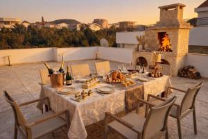 a table with food and wine on a patio with a fireplace at Villa Alera in Dobra Voda
