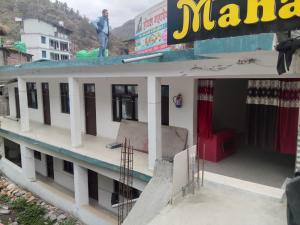 a man standing on the roof of a building at Hotel Mahadev in Sonprayag