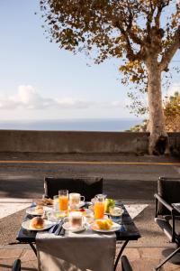 un tavolo con cibo e bevande sopra con vista sull'oceano di Positano Art Hotel Pasitea a Positano