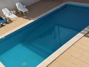 two chairs and a swimming pool with blue water at Large 2 bedroom Lagos apartment in Lagos