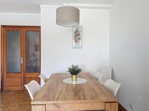 a dining room table with white chairs and a potted plant at BRESSOL DELUXE Apartments in Port de Pollensa