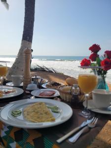 a table with food and drinks on the beach at B&B Klomiabla in San-Pédro