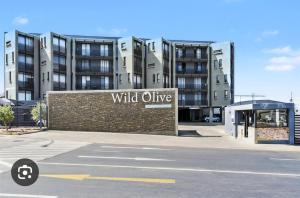 a building with a wild olive sign in front of it at Casa Solis at Wild Olive in Windhoek