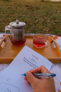 a person holding a piece of paper and a cup of tea at The CAMPIAN in Chiang Dao