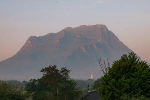 a large mountain in the distance with trees in the foreground at The CAMPIAN in Chiang Dao