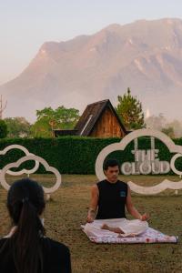 a man sitting in a meditation pose in front of a mountain at The CAMPIAN in Chiang Dao +244 photos