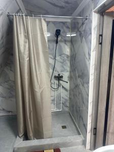 a shower with a shower curtain in a bathroom at A-Frame House Tosor in Tossor +21 photos