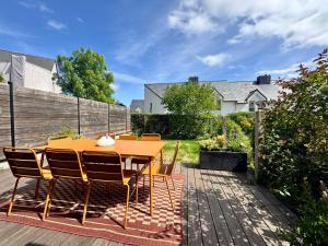 a patio with a wooden table and chairs at La Maison Contemporaine, Luxe et Elégance aux portes de Rennes in Cesson-Sévigné