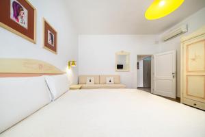 a bedroom with a large white bed in a room at NG Guest House Ammentos in Olbia