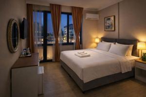 a bedroom with a large bed and a large window at Efes Artemis Hotel in Selçuk +55 photos