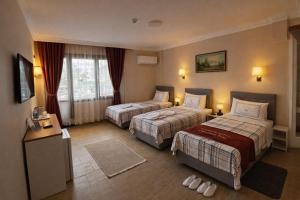 a hotel room with two beds and a window at Efes Artemis Hotel in Selçuk