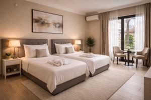 a bedroom with two beds and a table and chairs at Efes Artemis Hotel in Selçuk