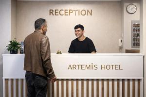 two men standing at a reception counter at anagents hotel at Efes Artemis Hotel in Selçuk