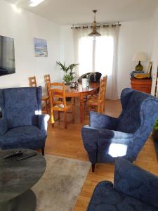 a living room with blue chairs and a table at Maison de Crozon in Crozon