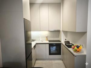 a kitchen with white cabinets and a bowl of fruit at Narcis in Užice