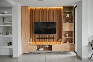 a living room with a television on a wooden entertainment center at Casa Solis at Wild Olive in Windhoek