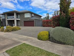 a house with a garage and some bushes at River view in Shepparton