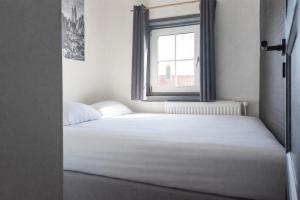a bed in a room with a window at Joy at the Beach in Zandvoort