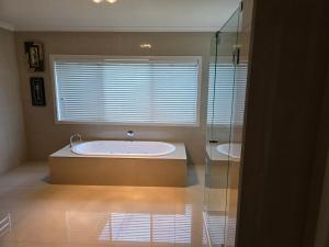 a bathroom with two tubs and a glass shower at River view in Shepparton +14 photos