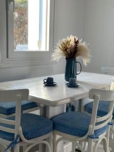 a table with chairs and a vase with flowers on it at Villa Manesi in Kithnos