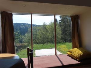 a bedroom with a large window with a view at The Ramsons - Čemaž Glamping in Železniki