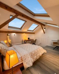 a bedroom with a large bed and a desk at DUPLEX SUBLIME ET LUMINEUX au CENTRE VILLE 10 minutes de Paris Parking privée souterrain in Rueil-Malmaison